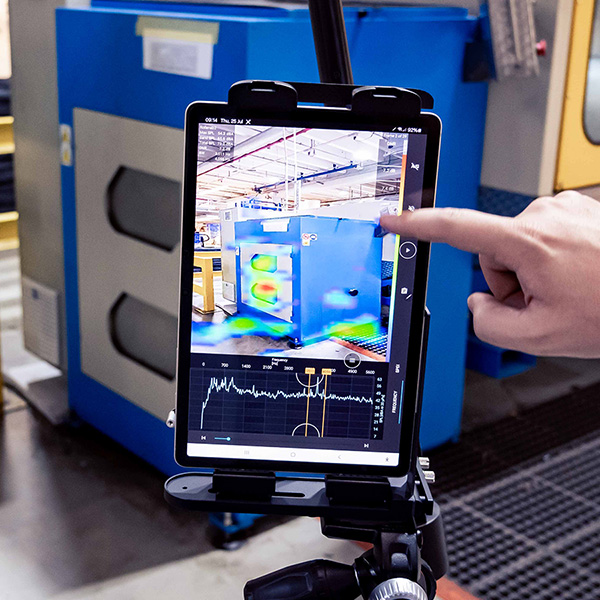 Tablet wird mit Finger bedient und zeigt eine Wärmebildansicht einer Maschine